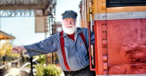 train conductor leaning out of parked train