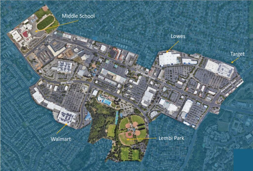 An aerial map view of a central business district with key locations labeled. In the center is a mix of commercial buildings and parking lots. Key points are marked with arrows: a Middle School at the top left, Lowe's in the upper right, Target to the far right, Walmart at the bottom left, and Lembi Park with sports fields toward the lower center. Major streets like Riley Street and East Bidwell Street run through the district, surrounded by residential neighborhoods.